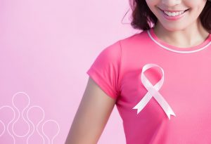 A woman wearing a pink ribbon to represent breast cancer awareness